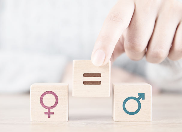 Illustration of three small wooden blocks. From left to right, the blocks are stamped with: the female gender symbol, the equal sign and the male gender symbol.